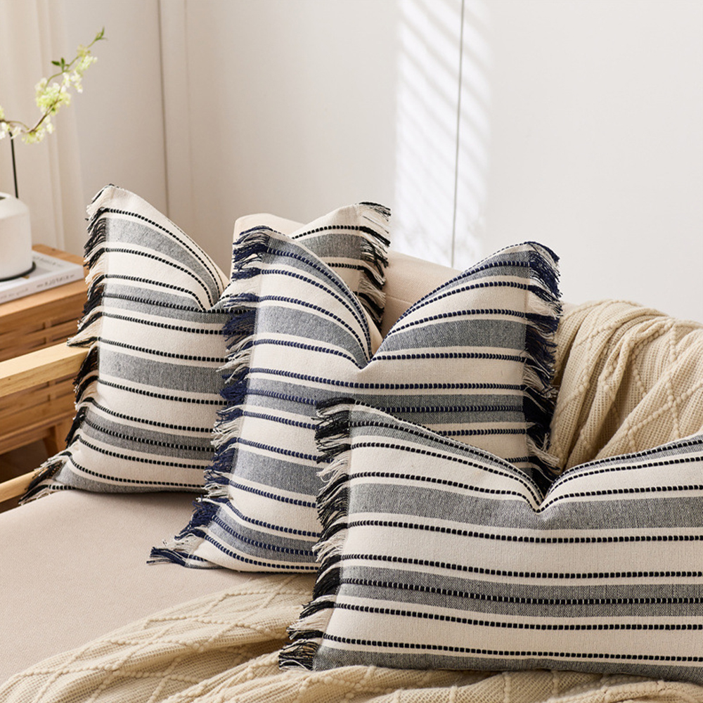 Coussin décoratif à franges avec pompons élégants.